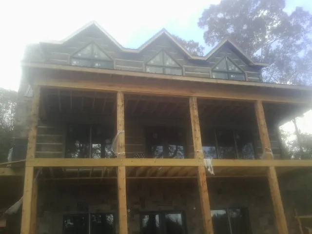 Dormers and porch framing on a large log home under construction — Roof Coating work by our crew in Venetia