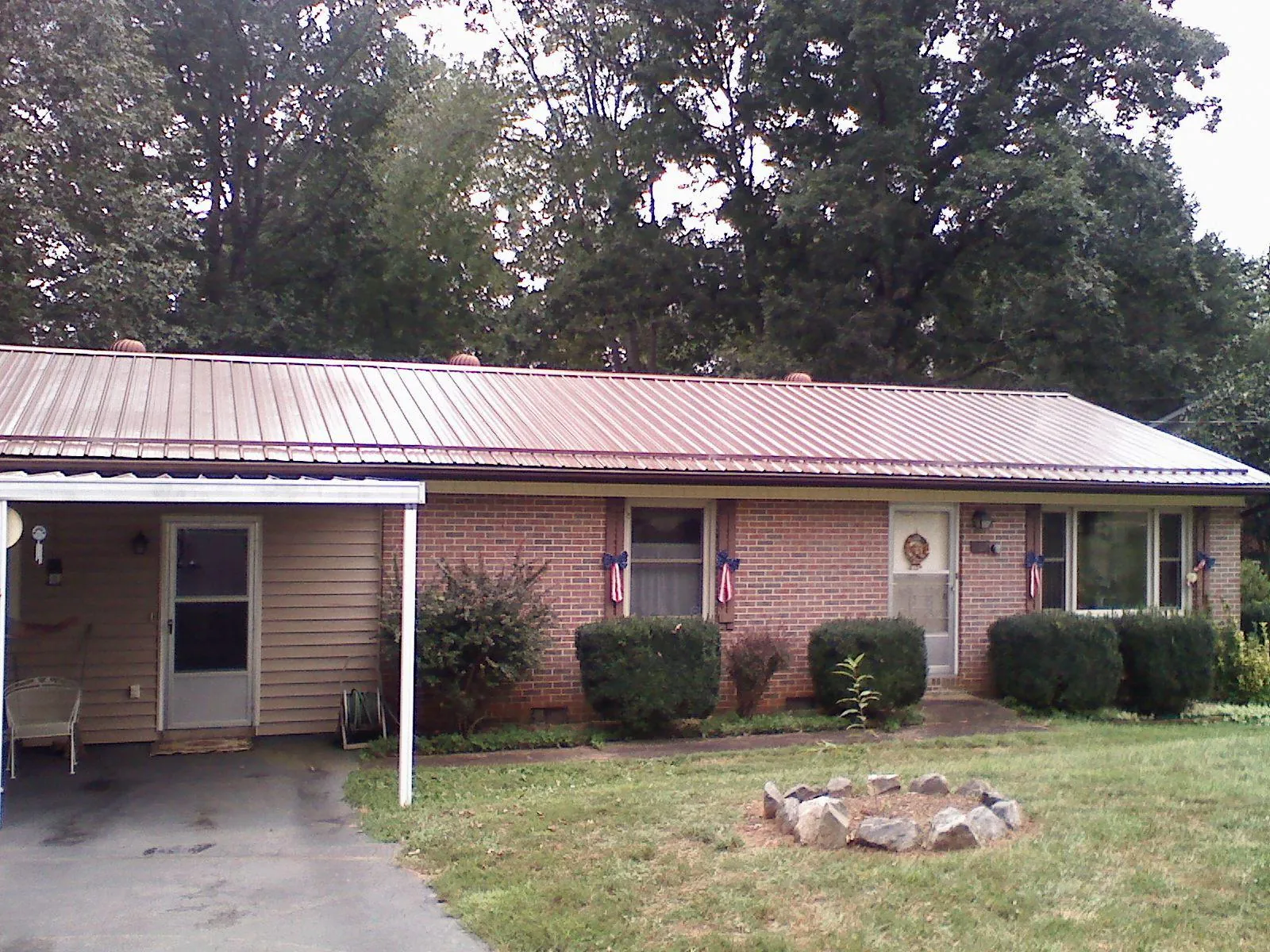 Bronze metal roof and carport on a brick ranch home — Roof Repair work by our crew in Venetia